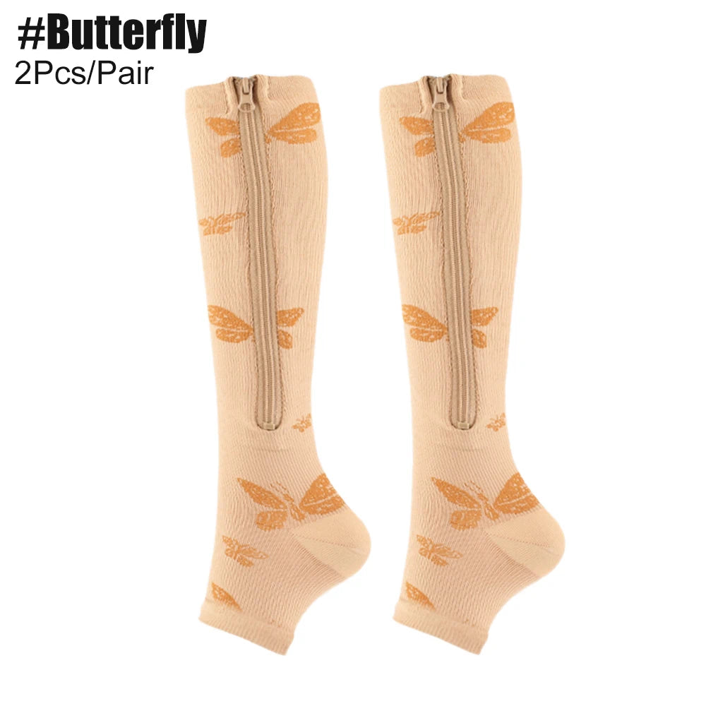 Beige knee-high compression socks with butterfly designs and zippers on a white background.