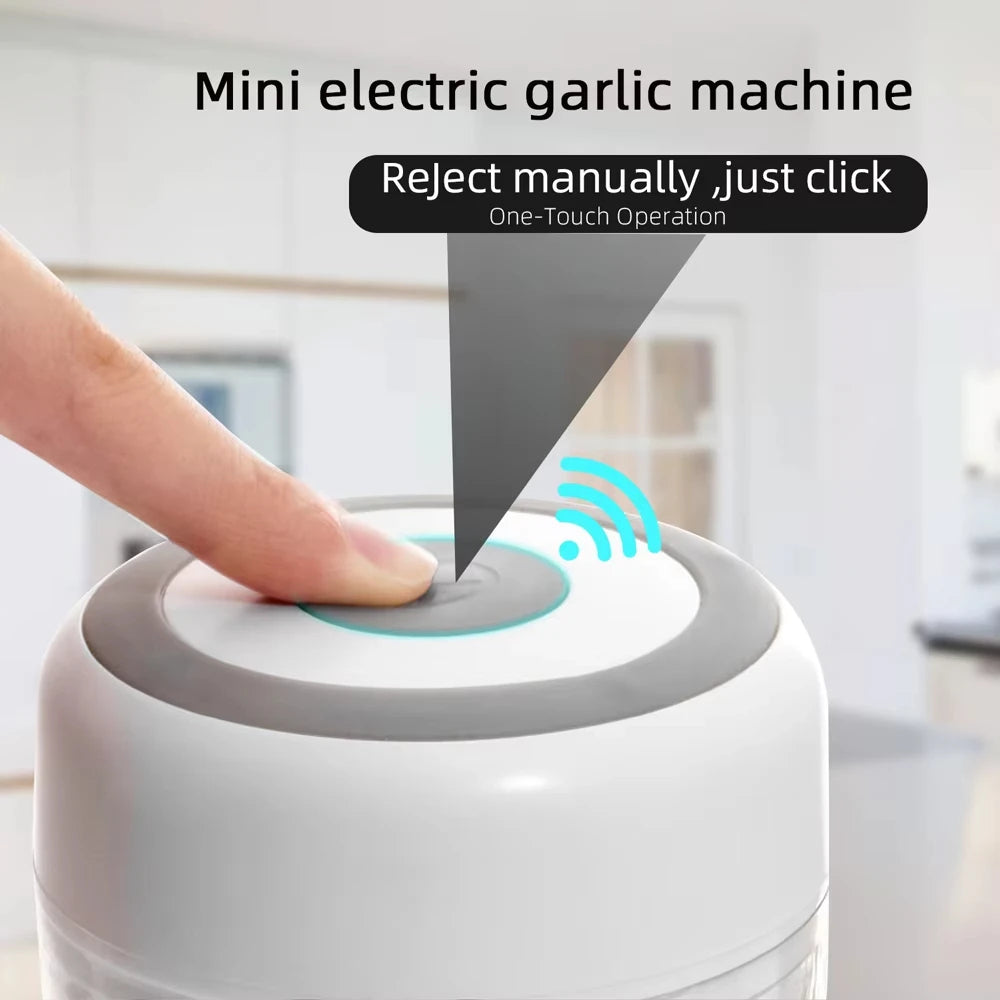 Mini electric garlic machine with a person's hand pressing a button, set against a blurred indoor background.